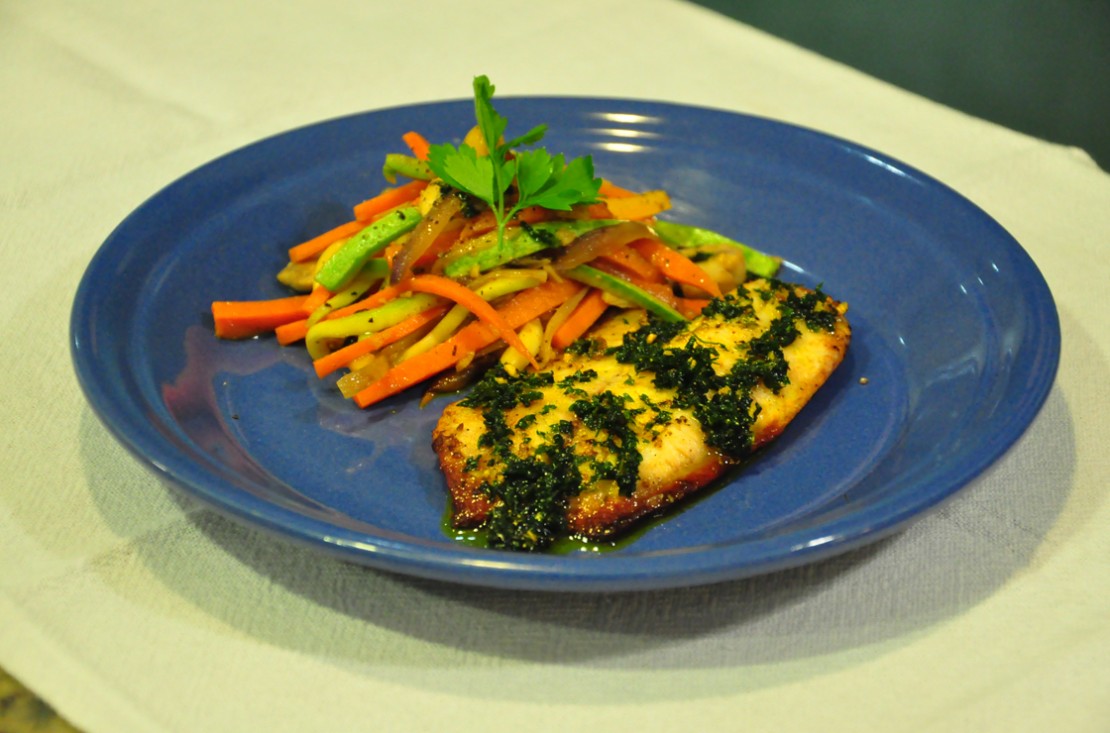 Receita de filé de tilápia com molho de ervas e legumes salteados.