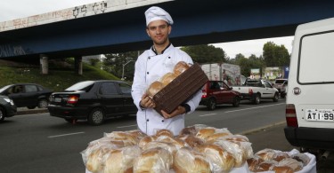 Rapaz faz pães para vender em sinaleiros de Curitiba. Foto: Átila Alberti/Tribuna do Paraná