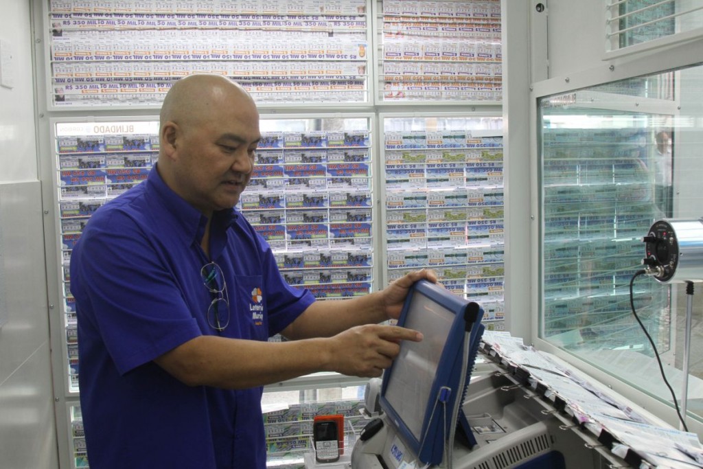 Auxilio Sugimoto, da Loterias Muricy, tem até uma sugestão de números para os indecisos. Foto: Gerson Klaina/Tribuna do Paraná