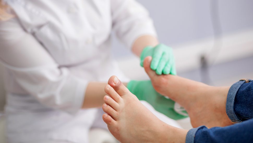 Médica examinando pés de paciente