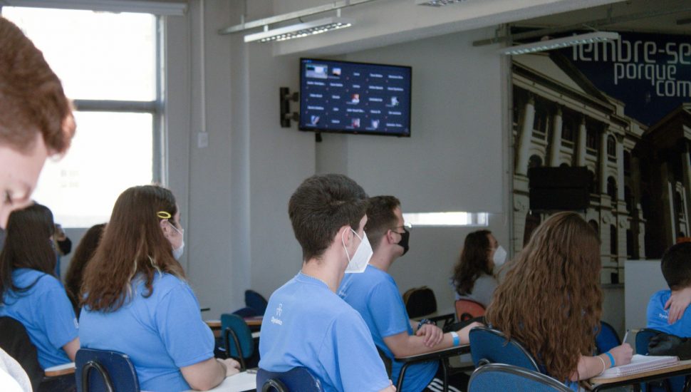 Em todas as salas de aula do Dynâmico existe uma TV onde aparecem as perguntas e interações dos alunos que assistem à aula em casa. | Foto: Divulgação