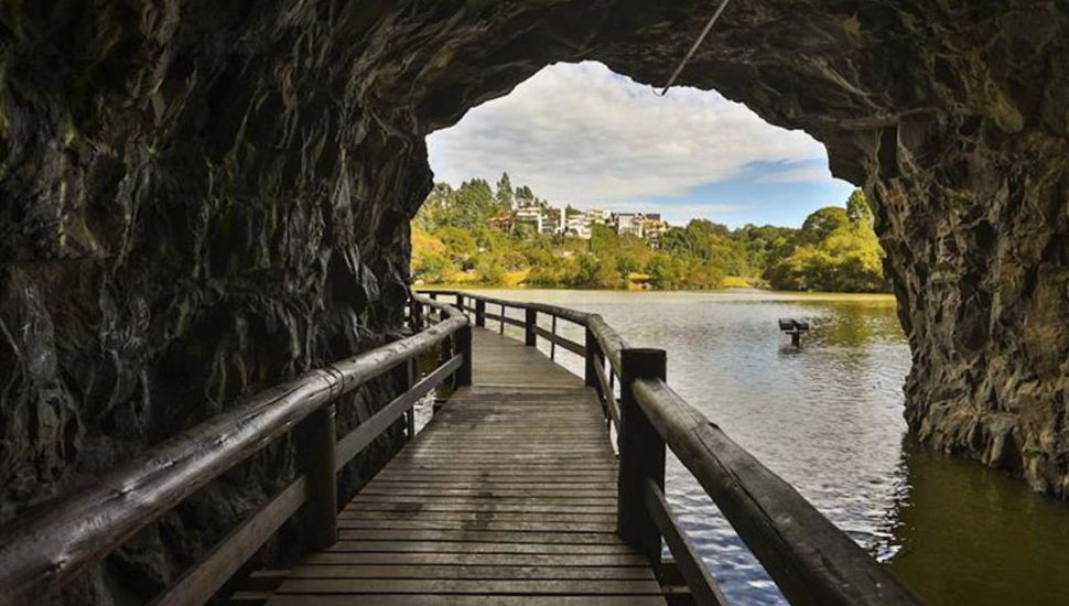 Túnel no Parque Tanguá tem passarela de madeira e corrimão de tronco, foi aberto para unir dois dos seus lagos e permitir ao visitante uma vista distinta do topo do belvedere.