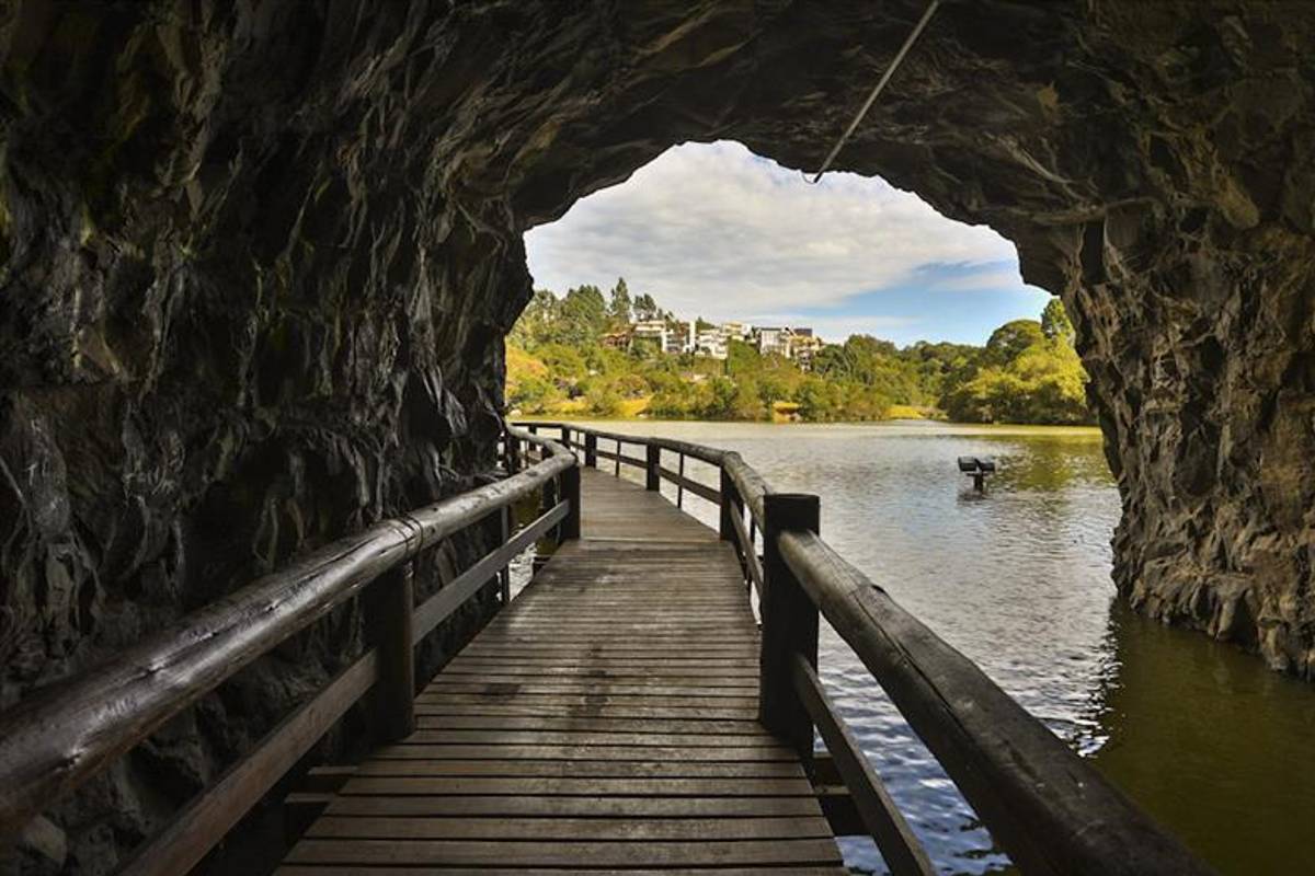 Túnel no Parque Tanguá tem passarela de madeira e corrimão de tronco, foi aberto para unir dois dos seus lagos e permitir ao visitante uma vista distinta do topo do belvedere.