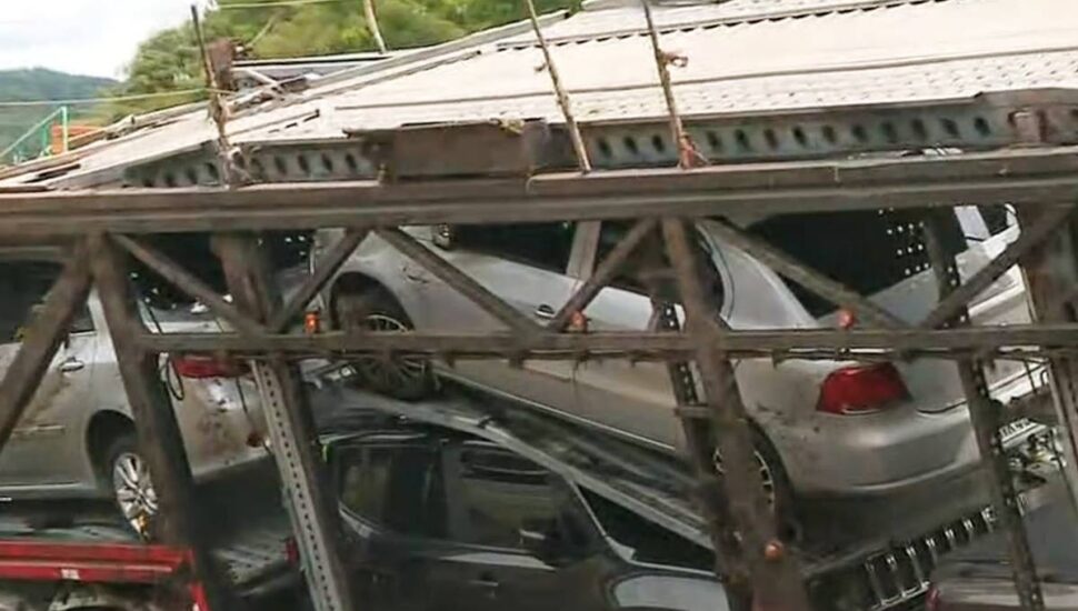Cegonheira tombou e derrubou veículos na pista.