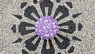 Imagem mostra, de cima, uma pessoa andando com guarda-chuva aberto no calçadão da Rua das Flores, em Curitiba.