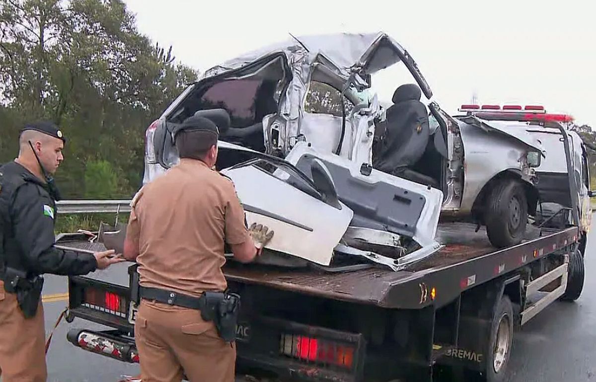 Guincho leva carro totalmentedestruído. Dois policiais acompanham a remoção