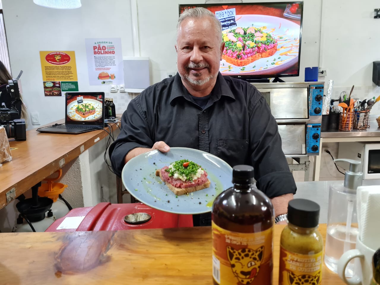 Criador do Festival da Carne de Onça, Sérgio Medeiros, segurando um prato com a iguaria curitibana