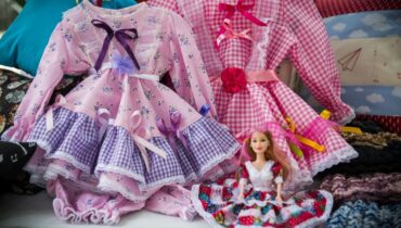 Na foto aparecem roupinhas de boneca feitas por artesãos