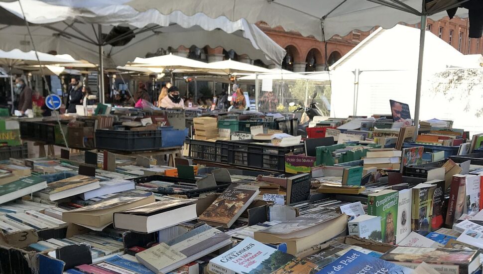 Imagem mostra várias caixas de livros debaixo de barracas em feira do livro na França