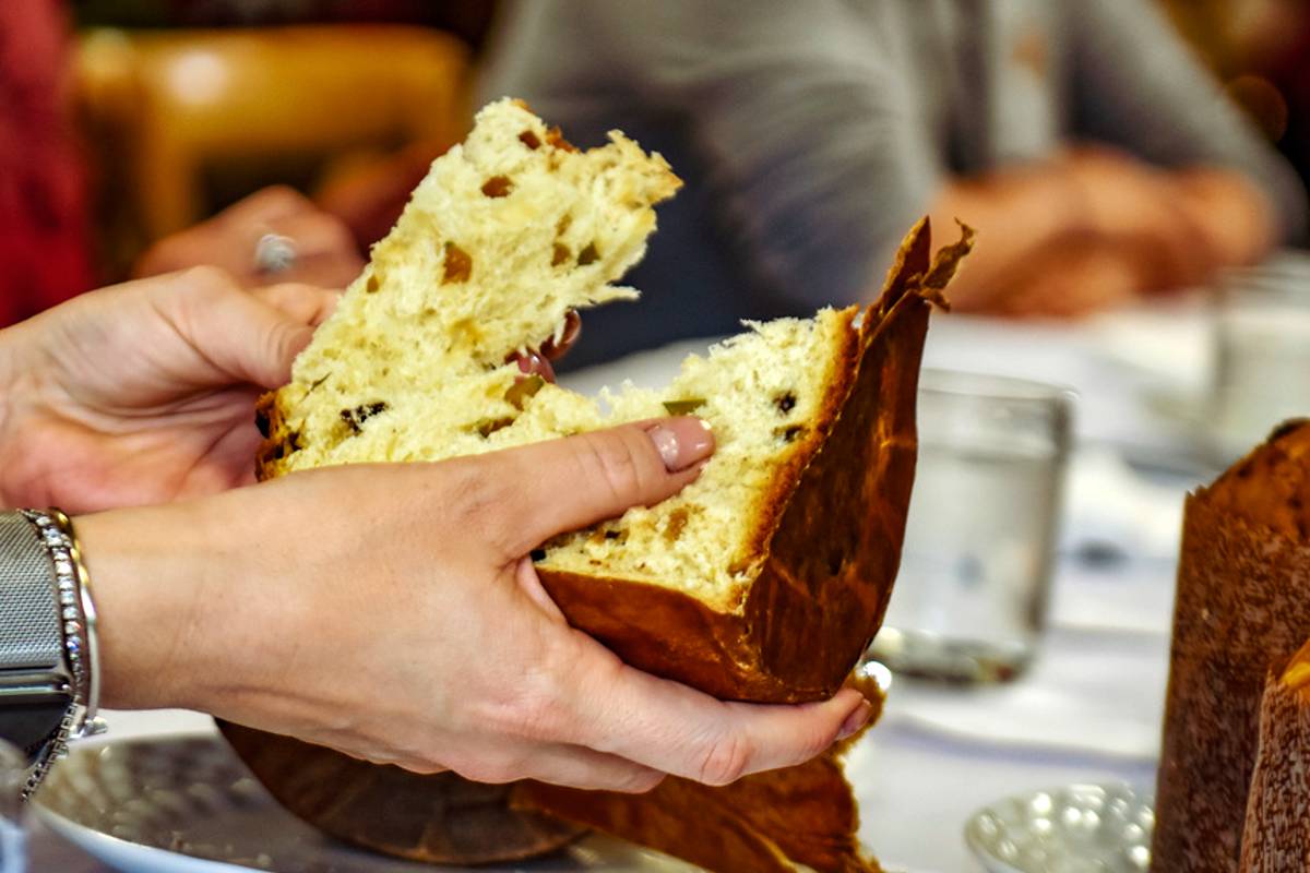 Imagem mostra um consumidor abrindo um panetone ao meio.