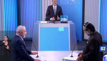 Imagem mostra o jornalista Willian Bonner apartando a discussão entre Lula e Padre Kelmon.