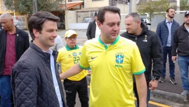 Governador do Paraná em primeiro plano, ao lado do vice prefeito de Curitiba, com a camisa da seleção brasileira