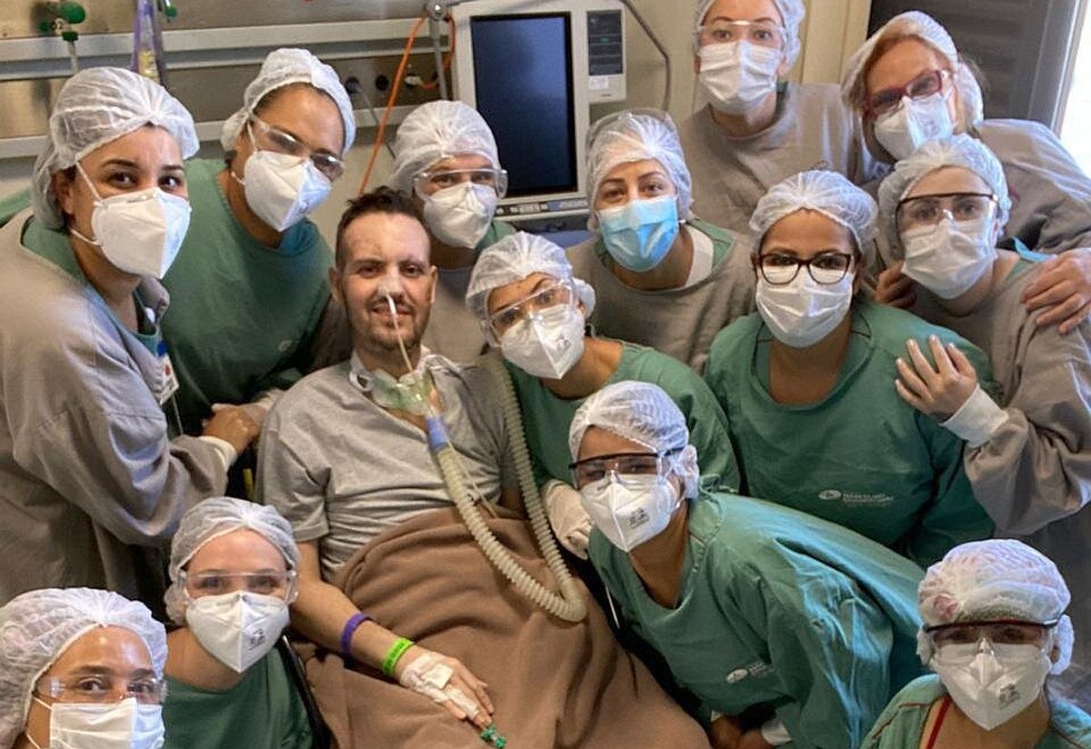 Paciente cercado por dezenas de enfermeiras que ajudaram no tratamento