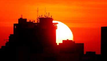 Imagem mostra o sol se pondo em Curitiba.