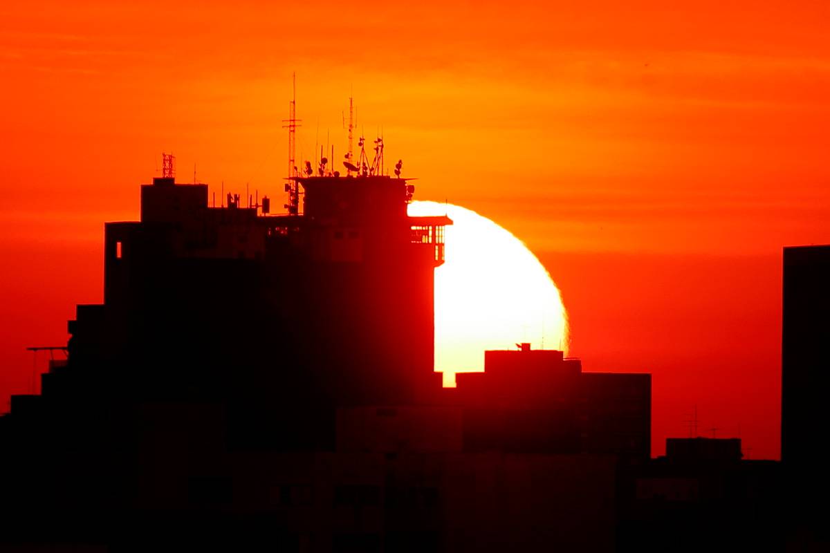 Imagem mostra o sol se pondo em Curitiba.