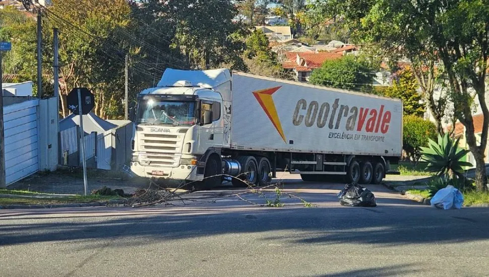 Imagem mostra um caminhão atravessado em uma rua de Curitiba
