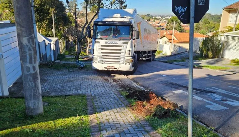 Imagem mostra um caminhão atravessado em uma rua de Curitiba