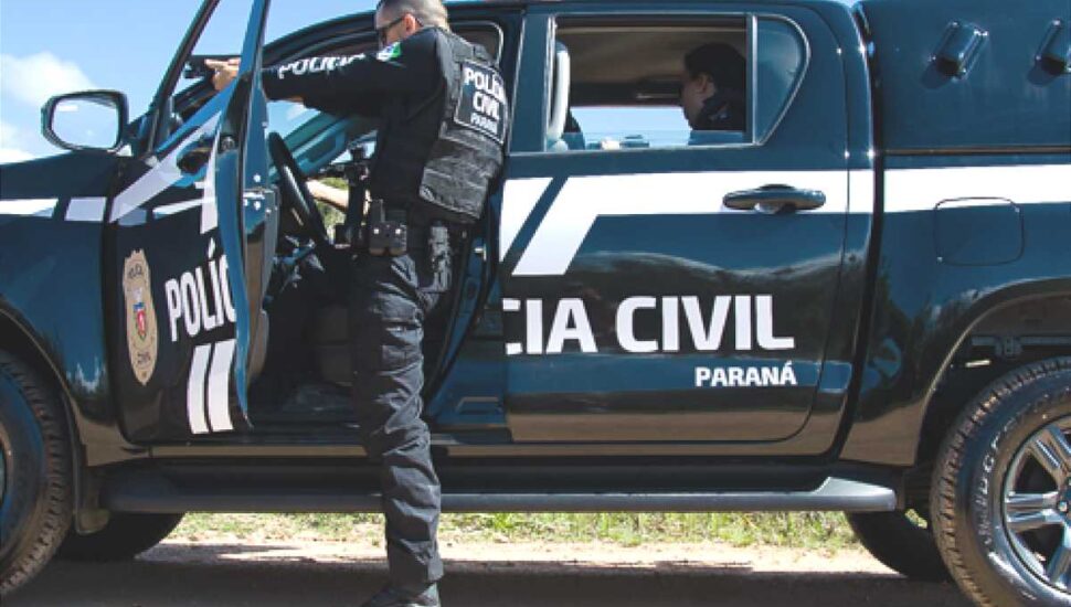 policial civil do Paraná se protege em uma viatura e mira com com uma arma