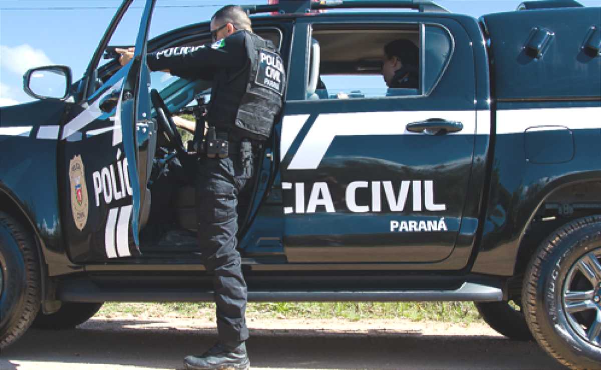 policial civil do Paraná se protege em uma viatura e mira com com uma arma