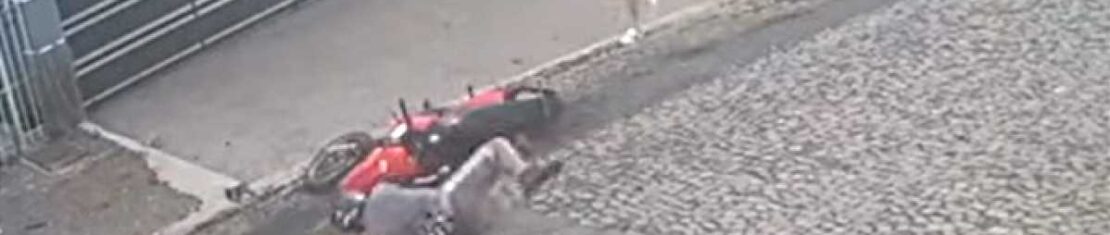 Motociclista em uma moto vermelha cai após dar tapa em uma mulher que caminhava na calçada em Ponta Grossa, no Paraná