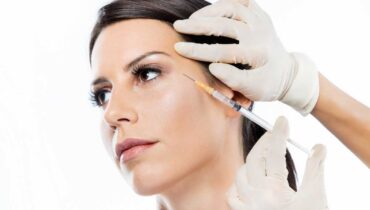 Mulher aplica botox em pacientes na região em volta dos olhos.