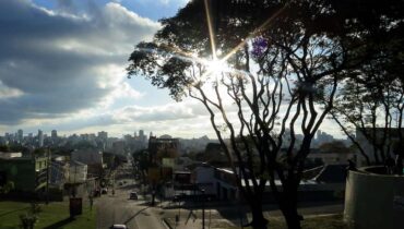 Curitiba em sol e nuvens de chuva ao fundo