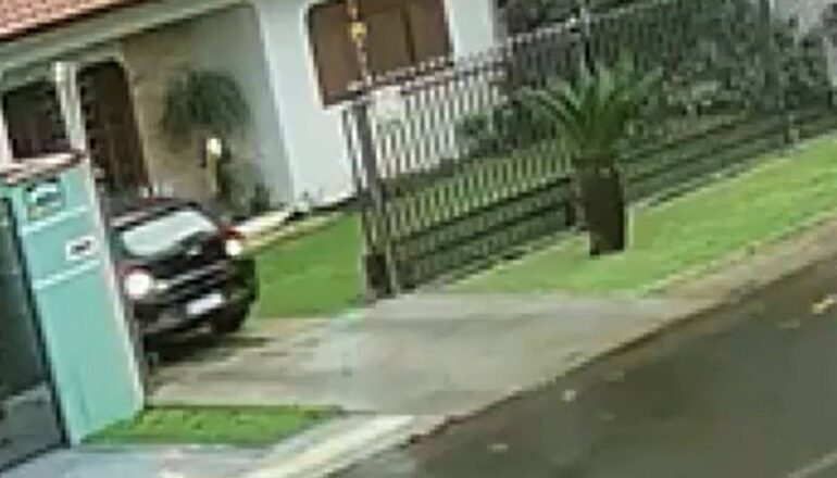 Carro preto deixa a entrada de uma casa no Paraná.