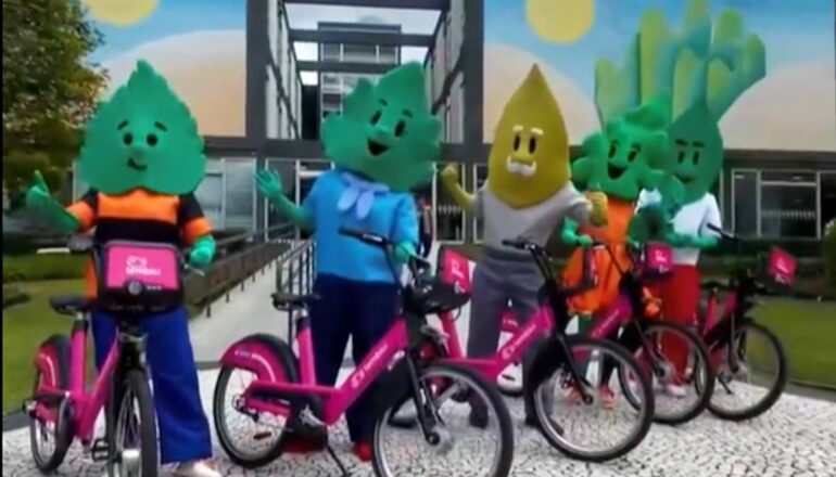 Familia folhas usa bicicleta compartilhada na frente da prefeitura de Curitiba