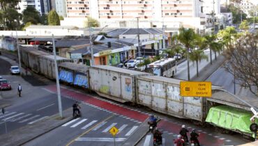 Trem cortando a rua nas proximidades da rodoferroviária de Curitiba