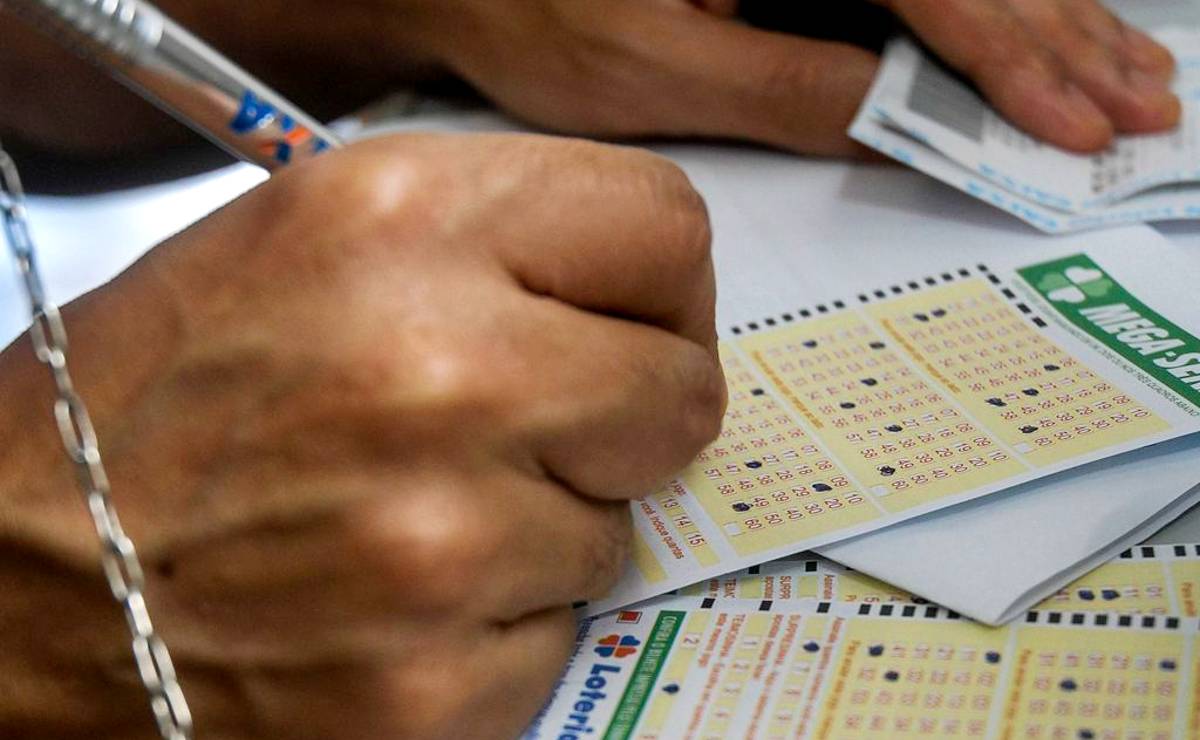 Imagem mostra um apostador da Mega Sena marcando seus números da sorte em um canhoto da Mega Sena