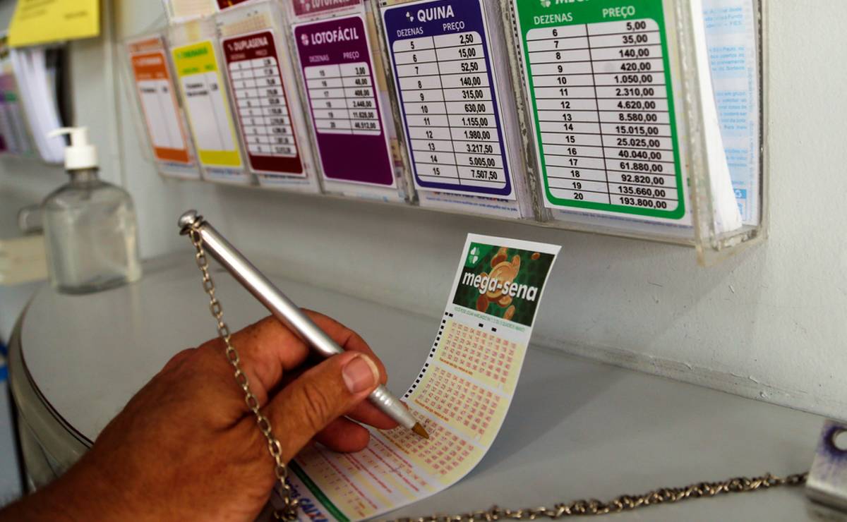 Imagem mostra um apostador da Mega Sena marcando seus números da sorte em um canhoto da Mega Sena