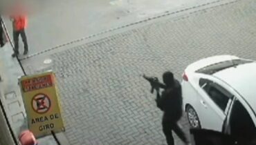 Imagem mostra homem armado dom fuzil durante assalto em posto de Curitiba