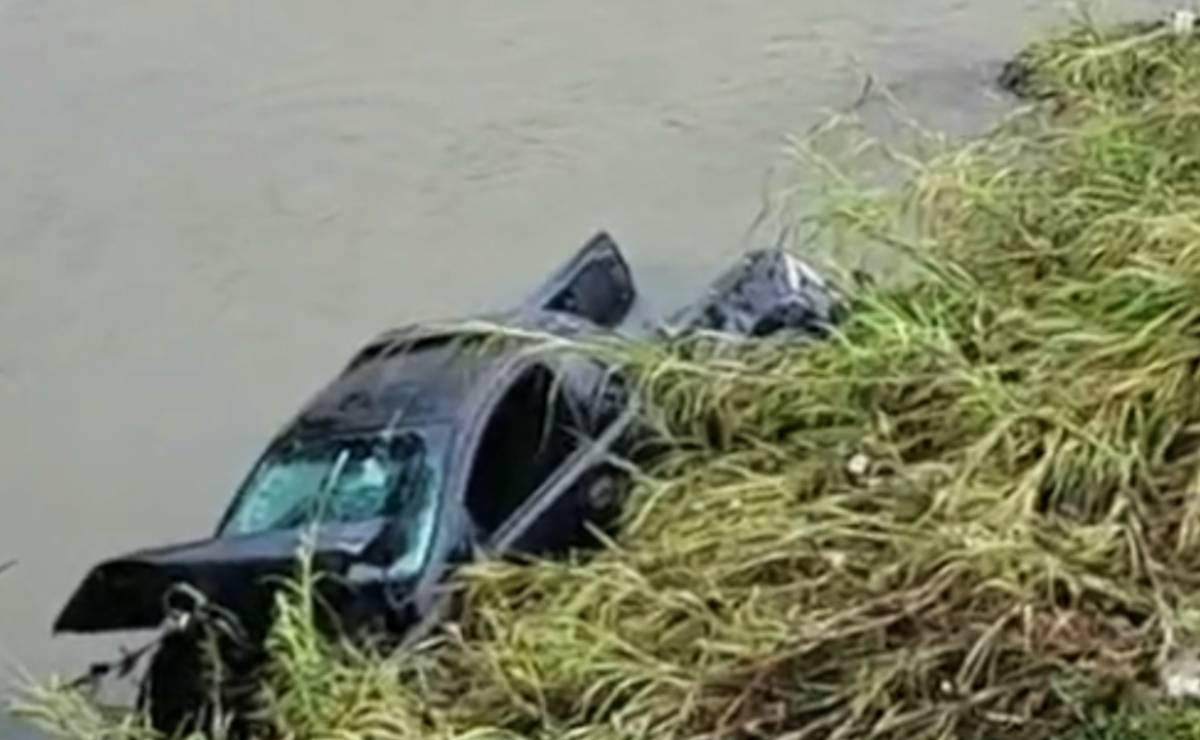 Imagem mostra uma caminhonete preta acidentada dentro do Rio Belém, em Curitiba