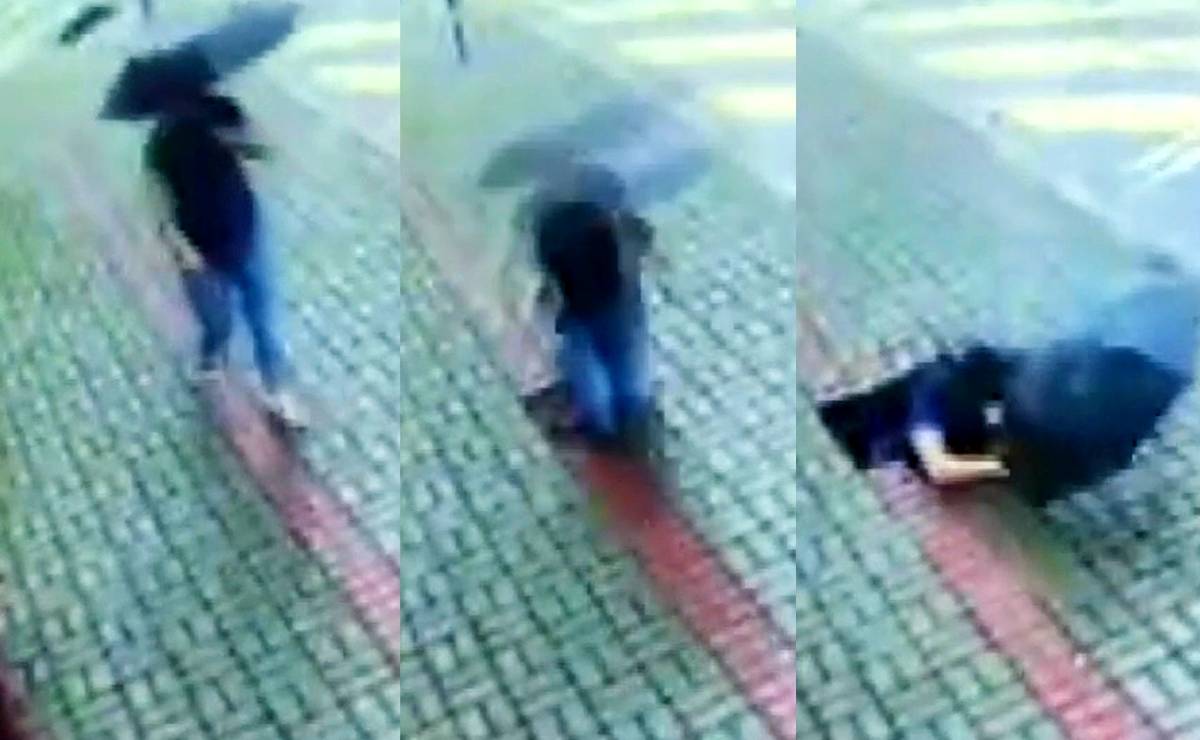 Imagem mostra uma mulher andando em uma calçada com um guarda chuva e sendo engolida por um buraco