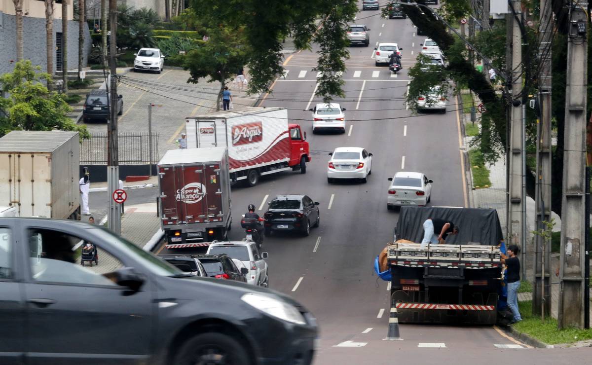 Imagem mostra carros circulando em uma movimentada rua de Curitiba