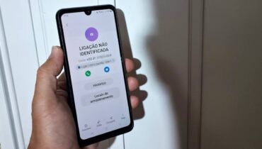 Imagem mostra um homem segurando um celular com chamadas perdidas