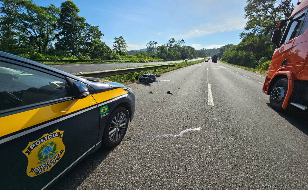 Imagem mostra a BR-277 com uma viatura na faixa esquerda e um caminhão na faixa da direita. A imagem de um sol brilhando num dia de céu limpo e calor