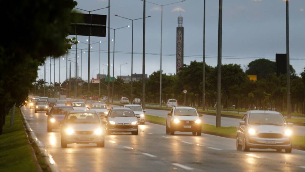 Imagem mostra o tempo fechado em Curitiba com carros circulando com as luzes acesas