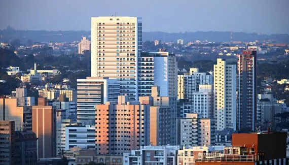 Imagem mostra os prédios em Curitiba com o pôr do sol