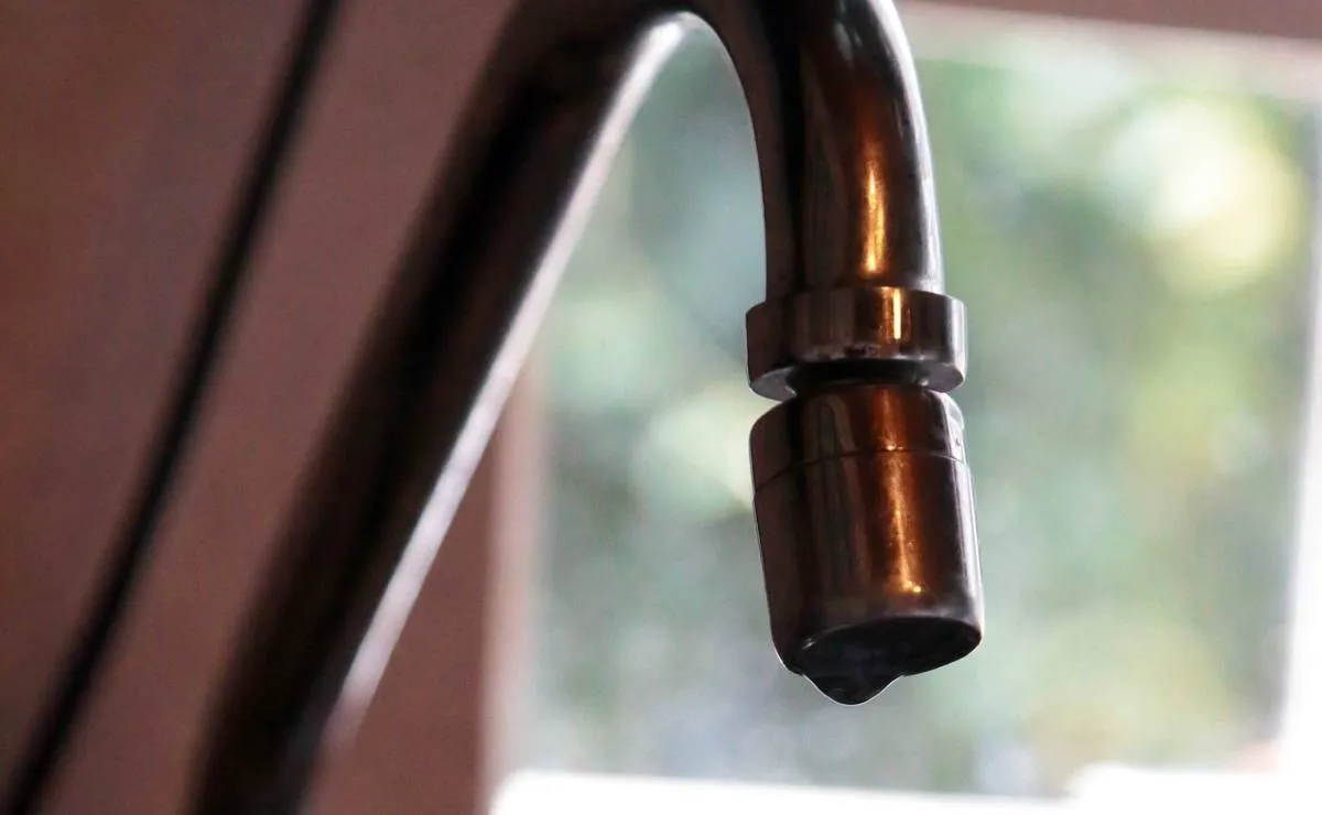 Imagem mostra uma torneira com uma gota de água.