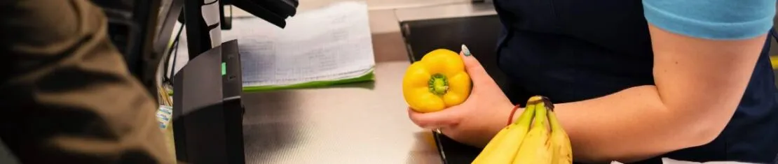 imagem mostra uma mulher trabalhando como caixa de supermercado.