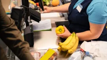 imagem mostra uma mulher trabalhando como caixa de supermercado.