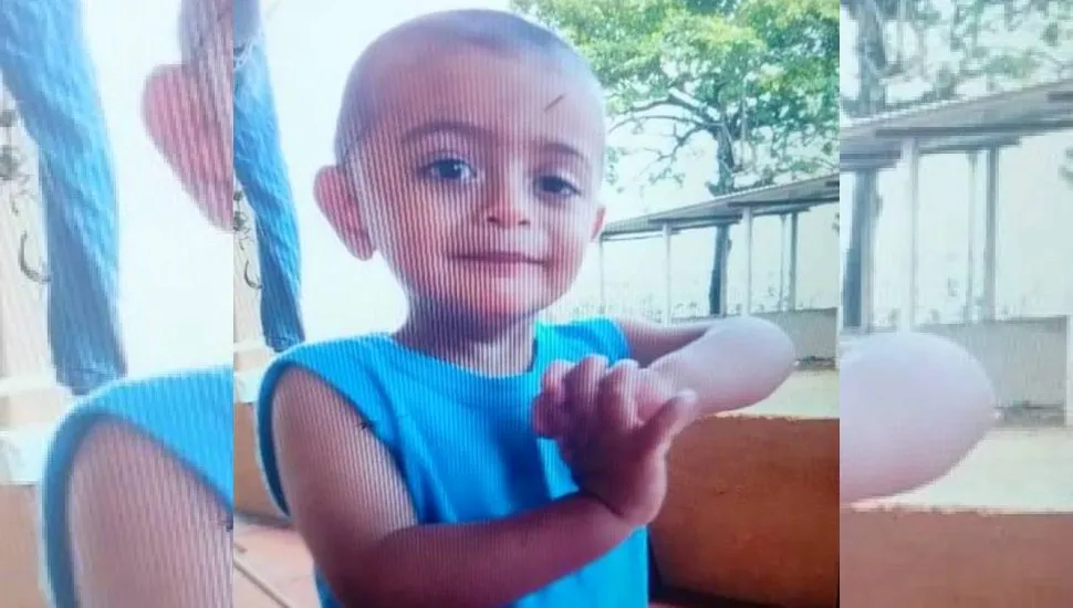 A imagem mostra uma criança desaparecido. Ele é o Arthur e está com uma camiseta azul olhando para a foto.