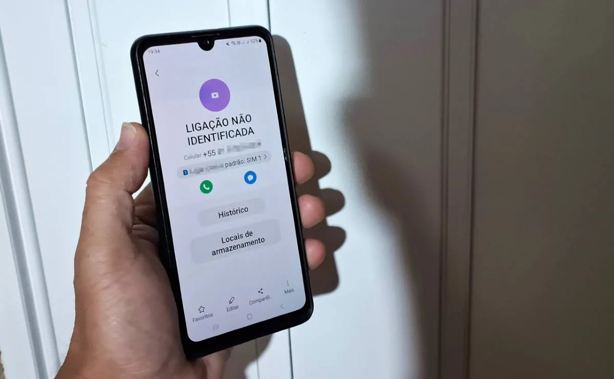 Na imagem, um telefone celular com "ligação não identificada" na tela.