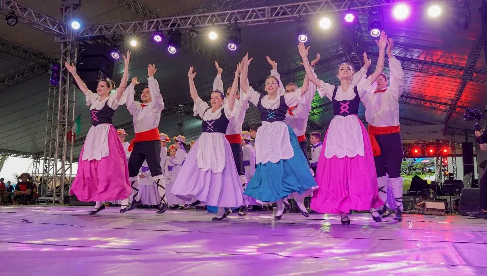 Grupo folclórico italiano dançando em cima de um palco.