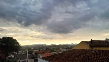 Imagem mostra o céu fechado em Curitiba, com possibilidade de chuva.