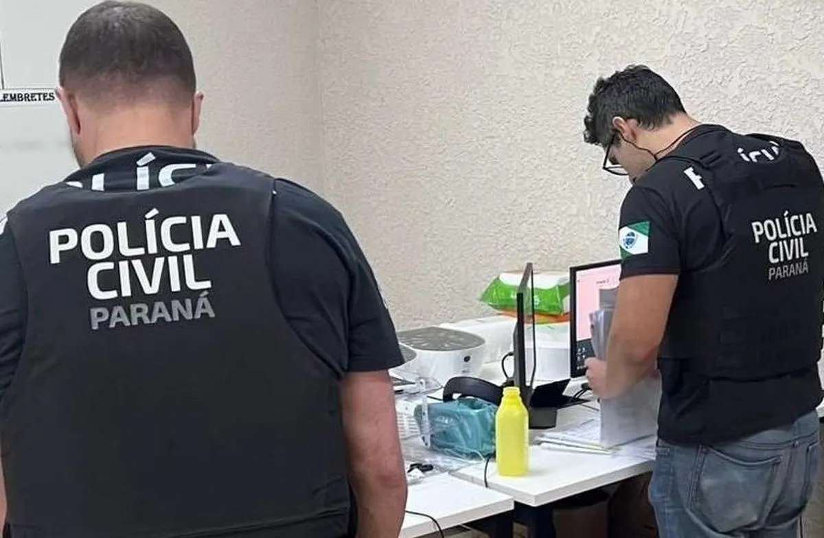 Na imagem, policiais de costas analisam documentos