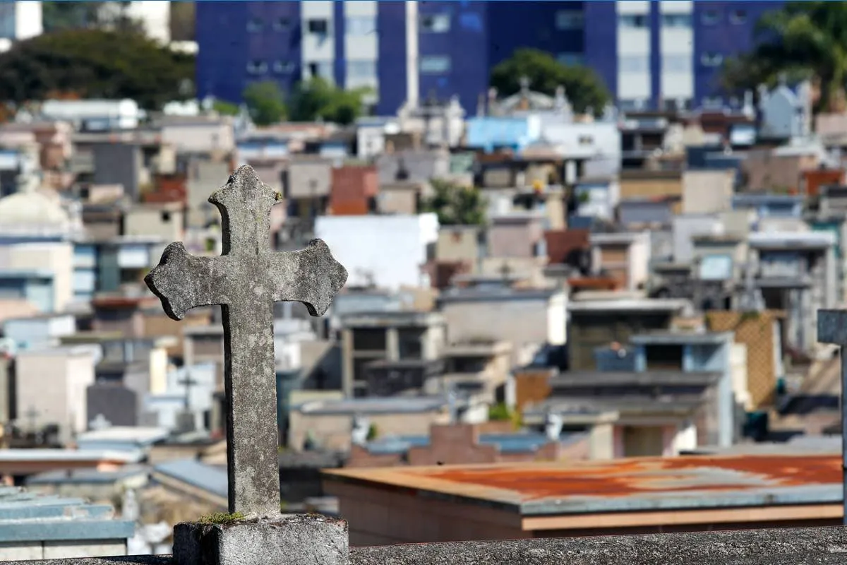 Imagem mostra um cemitério em Curitiba, com detalhes nos túmulos e em uma cruz.