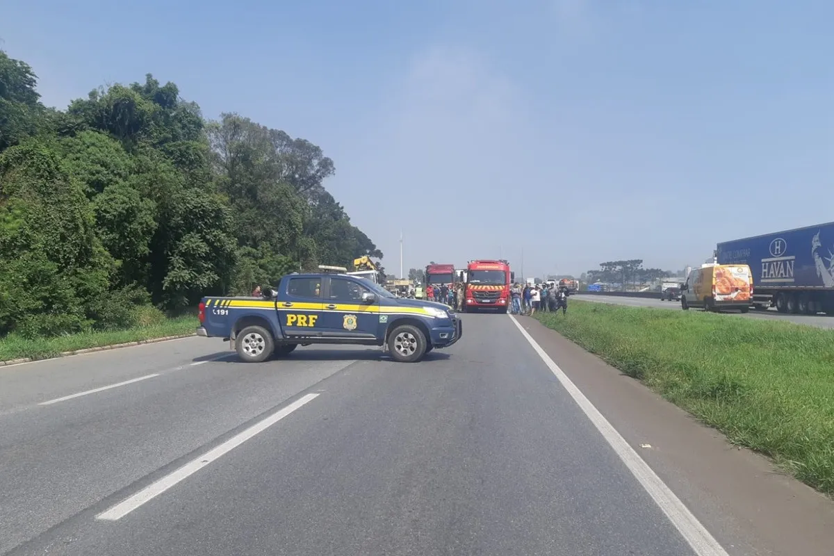 Imagem mostra viatura da PRF bloqueando pistas na BR-116 após acidente