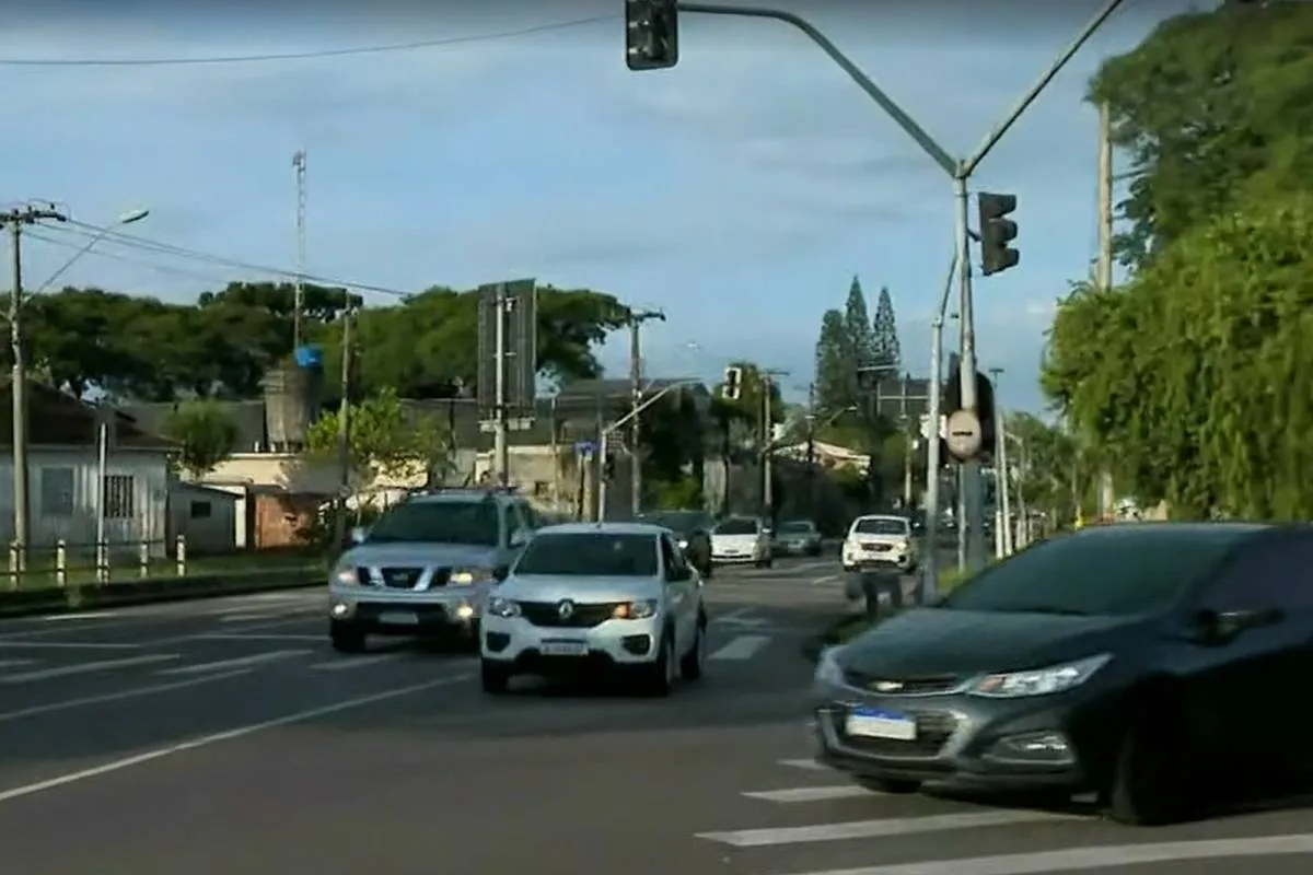 Imagem mostra carros andando em um cruzamento sem sinaleiro.
